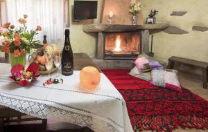 a table with a bottle of wine and a fireplace at Jaraiz in Laroya