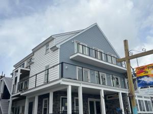 a large gray house with white trim on a street at Ocean Spray Inn in Winthrop