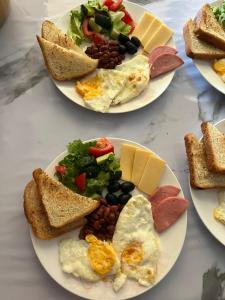 three plates of breakfast food on a table at Bugu Too Guest House in Kaindy