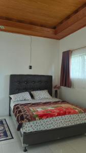 a bed in a bedroom with a wooden ceiling at Yus homestay in Bukittinggi +29 photos