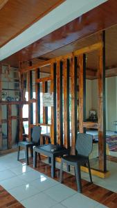 two chairs and a table in a room with wooden walls at Yus homestay in Bukittinggi