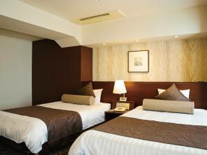 a hotel room with two beds and a lamp at Hotel Plaza Osaka in Osaka