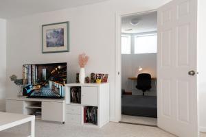 a living room with a tv and a white entertainment center at Cheng Rental in Surrey