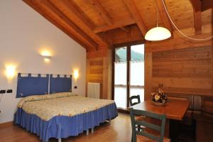 a bedroom with a bed and a table in a room at Residence Les Nigritelles in Cogne