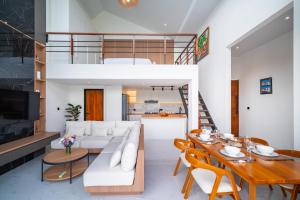 a living room with a white couch and a table at Villa Effata close to Black Sand Beach in Keramas