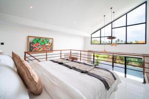 a bedroom with a bed and a balcony at Villa Effata close to Black Sand Beach in Keramas +112 photos