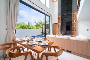 a dining room with a table and chairs and a couch at Villa Effata close to Black Sand Beach in Keramas