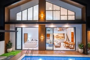 a house with a pool and a living room at Villa Effata close to Black Sand Beach in Keramas