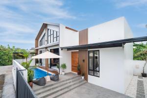 a house with a swimming pool and a patio at Villa Effata close to Black Sand Beach in Keramas