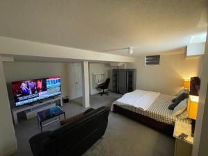 a bedroom with a bed and a flat screen tv at Comfort King in Oshawa