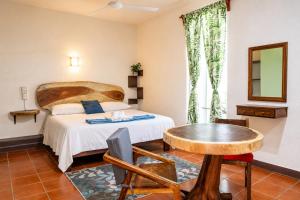 a hotel room with a bed and a table at Casa San Jerónimo in Puerto Escondido