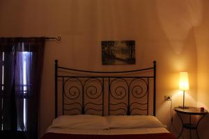 ペスカーラにあるBed & Breakfast Flaianoのベッドルーム1室(金属製ヘッドボードとランプ付きのベッド1台付)