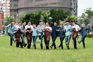 a group of people running in the grass at amba Taipei Ximending in Taipei