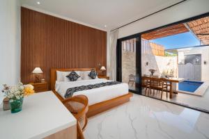 a bedroom with a bed and a table and a balcony at Villa Toograss close to Black Sand Beach in Keramas +78 photos
