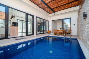 an indoor swimming pool in a house with a dining room at Villa Toograss close to Black Sand Beach in Keramas