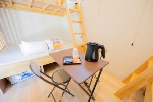 a small table with a coffee pot on it next to a bunk bed at NEW OPEN! HOTEL Kozafornia in Okinawa City