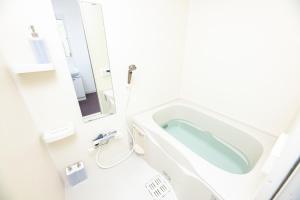 a bathroom with a bath tub and a toilet at SPAZIO 1 Canal Hakata Annex in Sumiyoshi