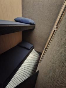 a staircase in a train with a blue seat at Capsule room with aircon in Manila