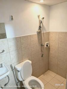 a bathroom with a shower with a toilet and a sink at Capsule room with aircon in Manila