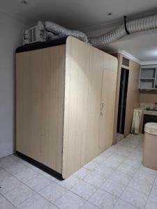 a large wooden cabinet with a door in a room at Capsule room with aircon in Manila