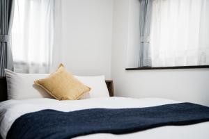a bedroom with a bed with a black blanket on it at SPAZIO 1 Canal Hakata Annex in Sumiyoshi