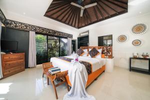 a bedroom with a large bed and a television at Katala Suites and Villas in Sanur