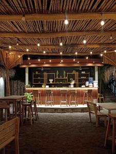 a restaurant with tables and chairs and a bar at Green Tree El Paredon in El Paredón Buena Vista