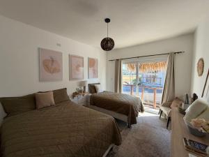 a bedroom with two beds and a couch and a window at Green Tree El Paredon in El Paredón Buena Vista