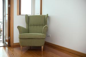 ポルトにあるBelomonte River View Apartmentsの窓際の部屋に緑の椅子