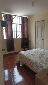 a bedroom with a bed and a large window at La casa de Manuel in Lunahuaná
