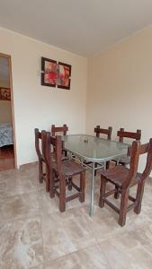 a dining room with a glass table and chairs at La casa de Manuel in Lunahuaná