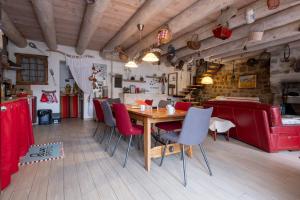 a dining room with a wooden table and red chairs at Gîte oya in Chaudeyrac