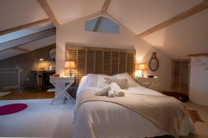 a bedroom with a bed with two stuffed animals on it at Gîte oya in Chaudeyrac
