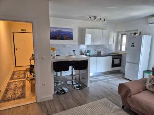 a kitchen and living room with a counter and a refrigerator at Apartman Sanja in Ploče +26 photos