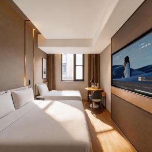 a hotel room with a bed and a flat screen tv at Atour on the Bund in Shanghai