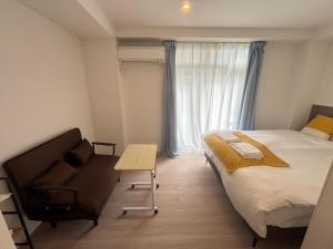 a bedroom with a bed and a chair and a table at New Happy Smile-Self Check In in Tokyo