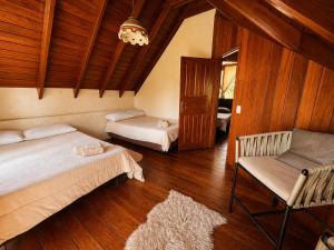 a bedroom with two beds and a chair in it at Valle Verde Lodge - Bosque in Samaipata