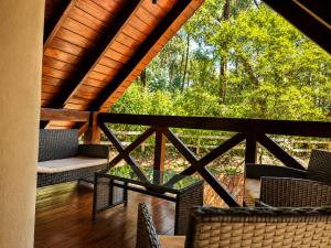 a screened porch with chairs and a view of the woods at Valle Verde Lodge - Bosque in Samaipata