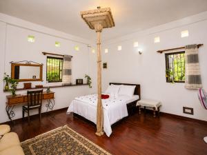 a bedroom with a bed and a table and a mirror at Hilltop Retreat Matale in Matale