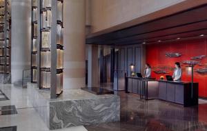a hotel lobby with two women sitting at a counter at Grand Hyatt Hangzhou in Hangzhou +70 photos