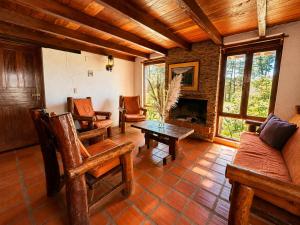 a living room with a table and chairs and a fireplace at Valle Verde Lodge - Bosque in Samaipata +3 photos