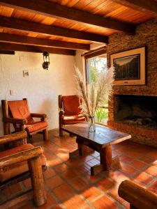 a living room with a table and a fireplace at Valle Verde Lodge - Bosque in Samaipata