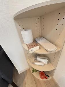a cupboard with a shelf with toilet paper and other items at New Happy Smile-Self Check In in Tokyo