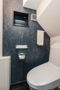 a bathroom with a toilet and a black wall at こだま屋 in Tokyo