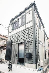 a black dog sitting in front of a building at こだま屋 in Tokyo