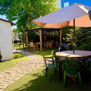 a wooden table and chairs with an umbrella at Vadim Home 2 in Ventspils