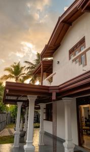 a large white house with a wooden roof at Lunara Sanctuary in Induruwa