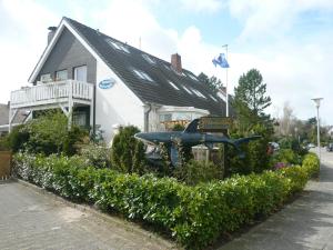 une maison avec une statue d'oiseau devant de celle-ci dans l'établissement "Haus am Deich", à Cuxhaven