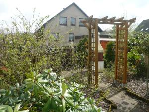 un jardin avec une pergola en face d'une maison dans l'établissement "Haus am Deich", à Cuxhaven 24 autres photos