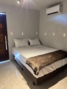 a bedroom with a bed with a blanket on it at Pousada Bonetti Quarto 11 in Santa Rosa +4 photos